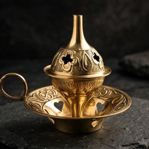 Brass cone incense burner on dark slate