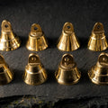 Mini brass bells on dark slate