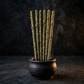 Six hand-rolled mugwort incense sticks on dark background