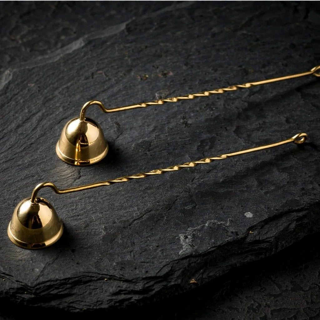 Solid brass candle snuffers on dark slate