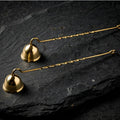Solid brass candle snuffers on dark slate