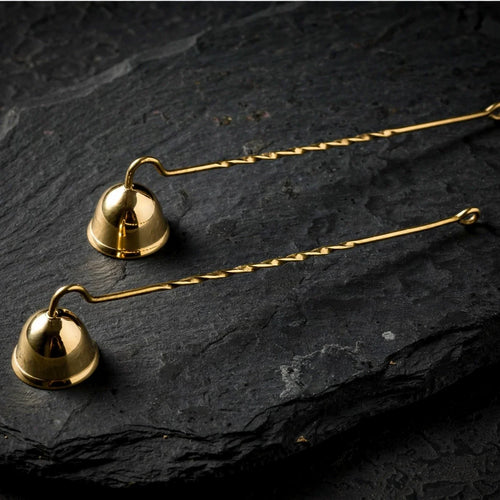 Solid brass candle snuffers on dark slate